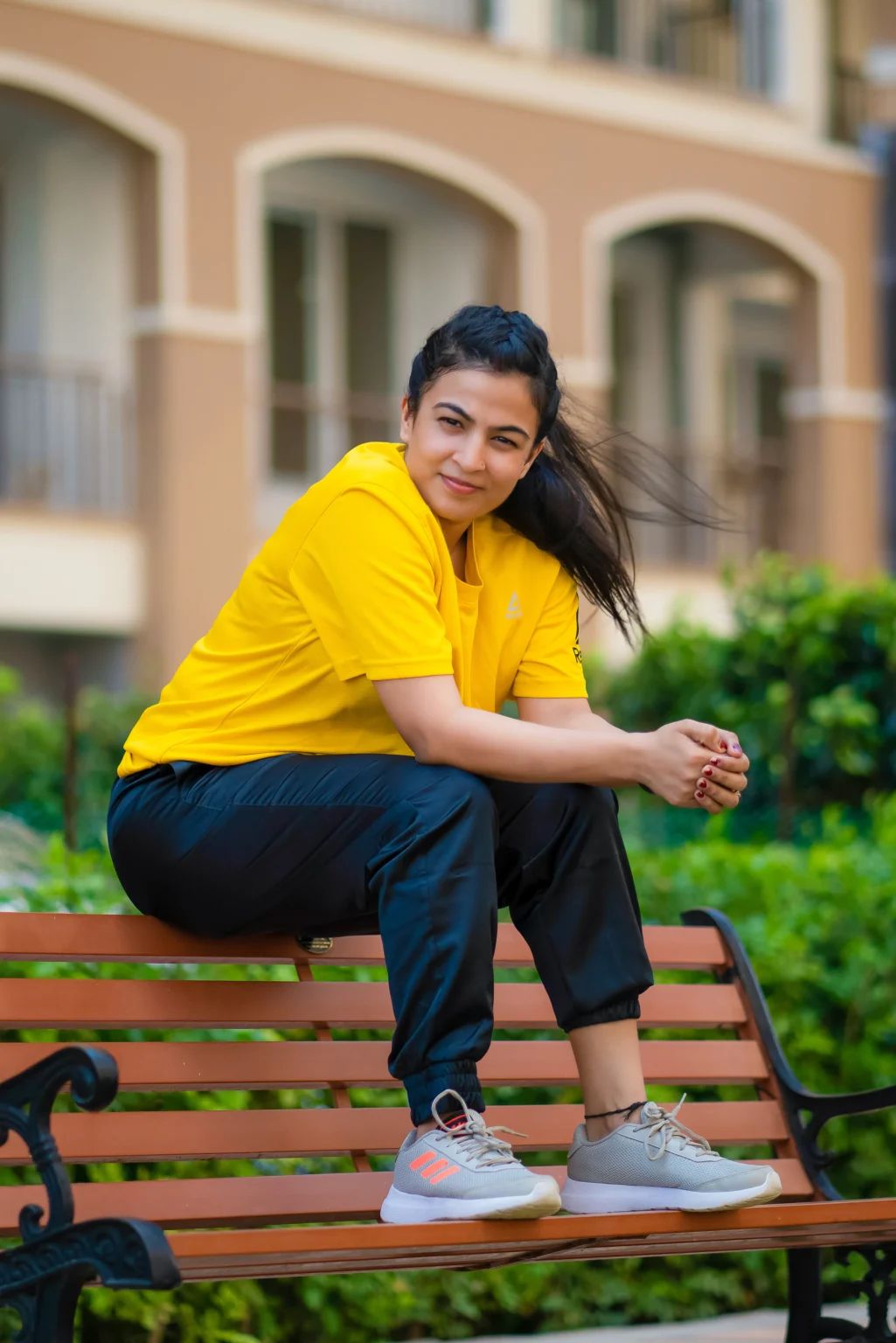 Dr. Jyoti Srivastava in a yellow workout T-shirt, sitting on a garden bench