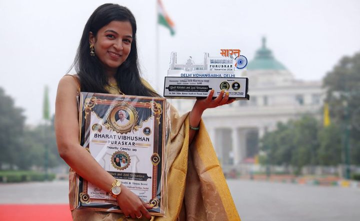 Jyoti holding the Bharat Vibhushan Puraskar 2024 award outside Delhi Vidhan Sabha