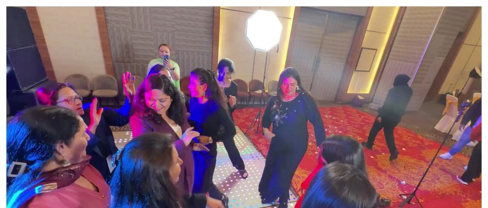 Superwomen dancing together on a lit dance floor