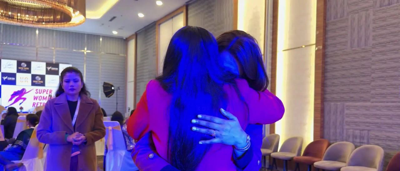Dr. Jyoti hugging a member under soft purple light