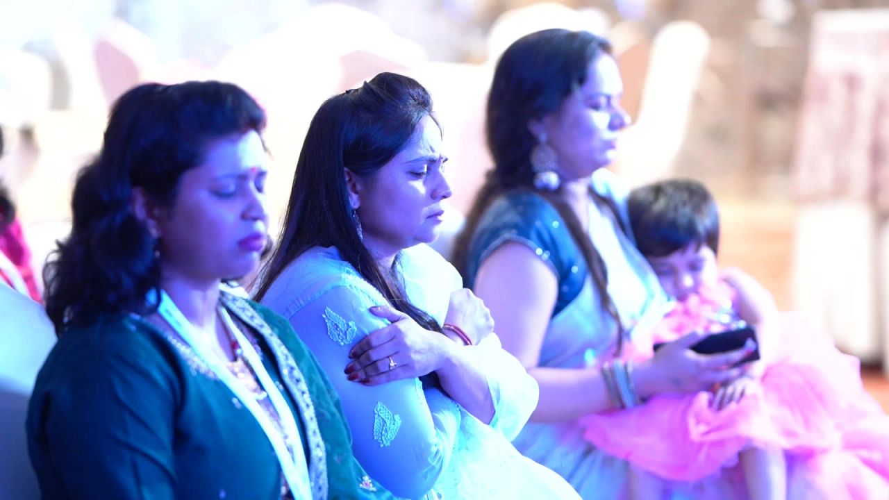 Members sitting quietly during a mindful moment, one holding her child