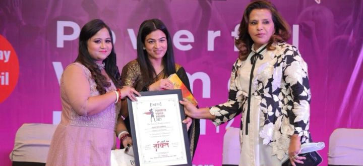 Jyoti on stage receiving a Powerful Women Awards 2021 certificate